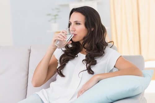 Kvinde drikker vand som en del af en kulhydratfattig kost