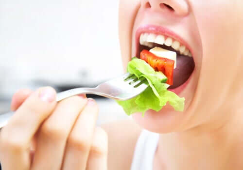 A woman trying to chew her salad.