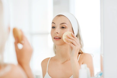 En kvinde renser sit ansigt med en svamp