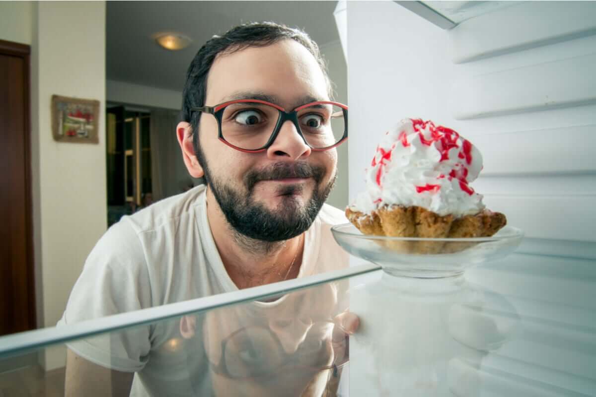 Emotionales Essen stoppen - Mann vor einem Dessert im Kühlschrank