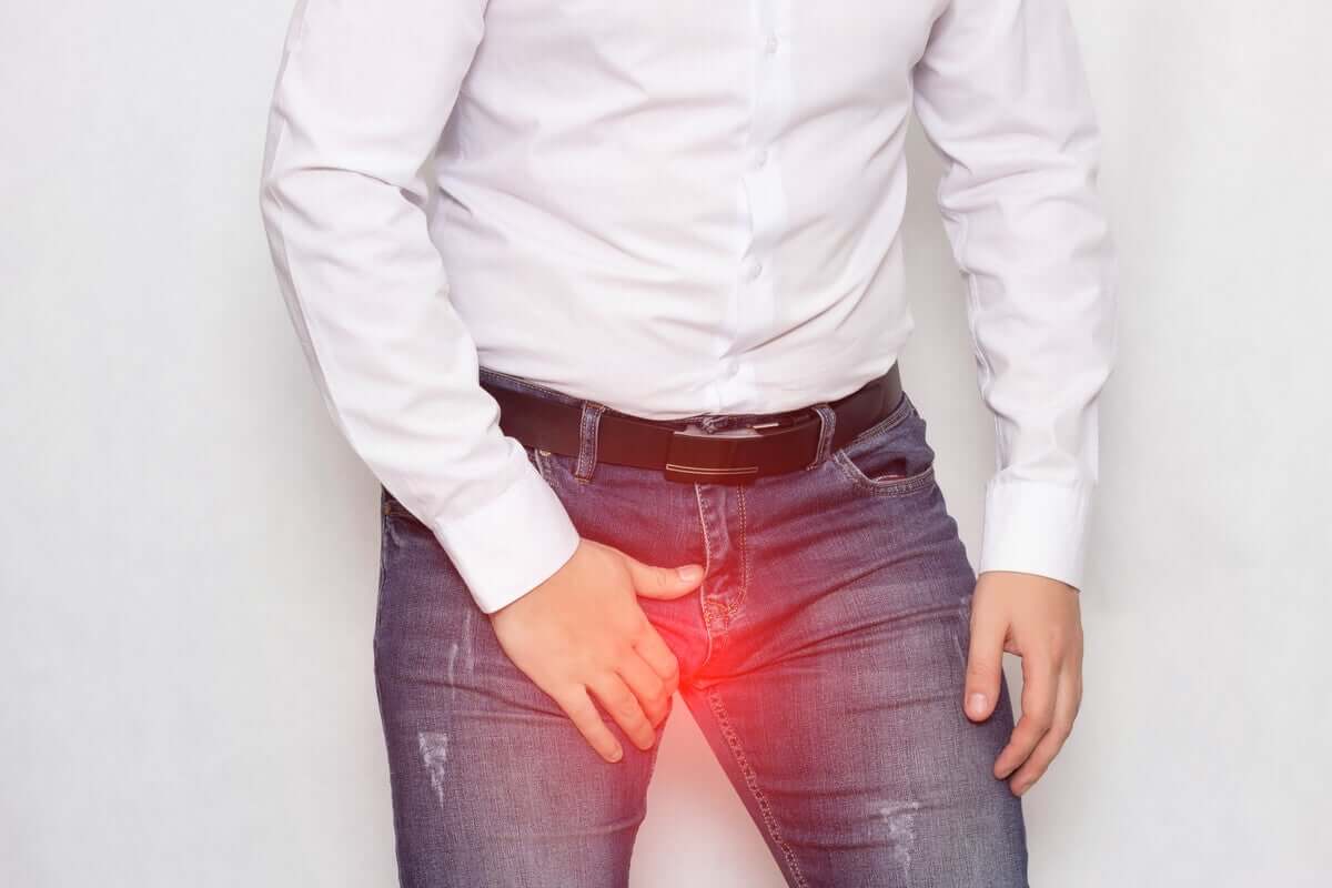 A man hunched over, holding onto his groin.