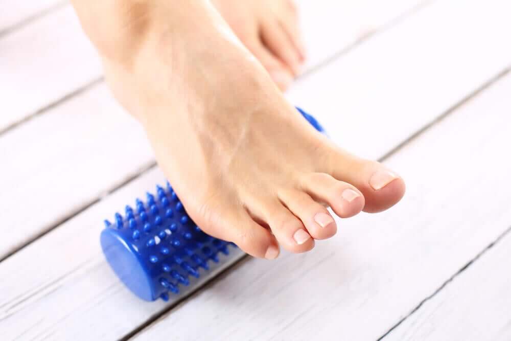 A woman rolling her foot over a foot massager.