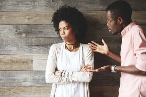 A woman looking away while her partner talks to her.