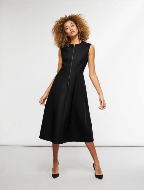 A woman wearing a black medium-length dress.