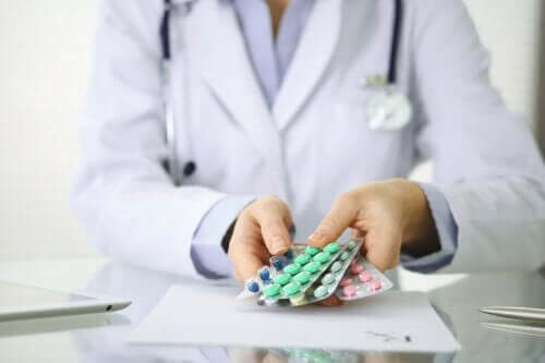 A doctor handing a patient a variety of medications.