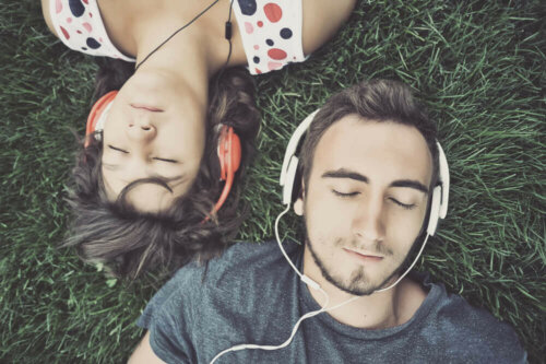 two people lying on the grass with headphones on