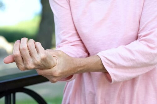 woman with pain in her wrist holding her wrist