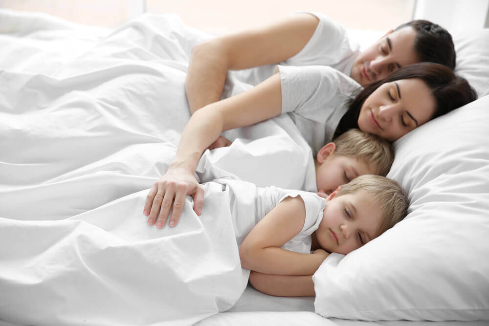 En familie som sover i sengen