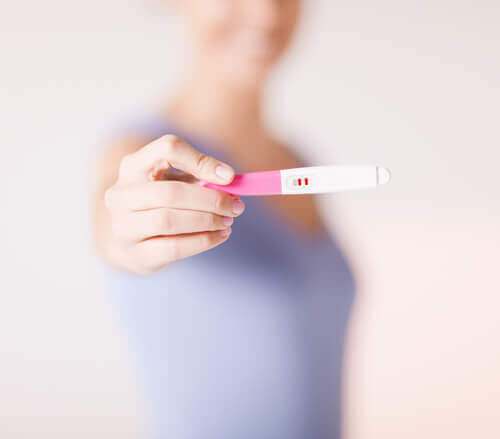 Μια γυναίκα που δείχνει θετικό τεστ εγκυμοσύνης.