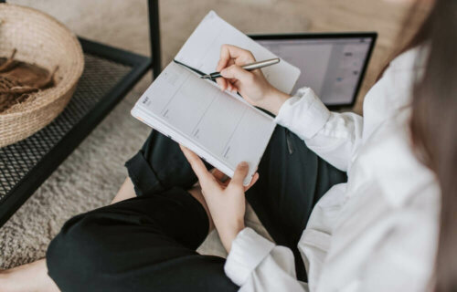 En kvinne som skriver ned sine SMARTE mål.