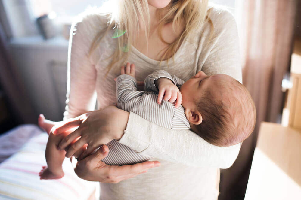 Kvinde bærer sin nyfødte