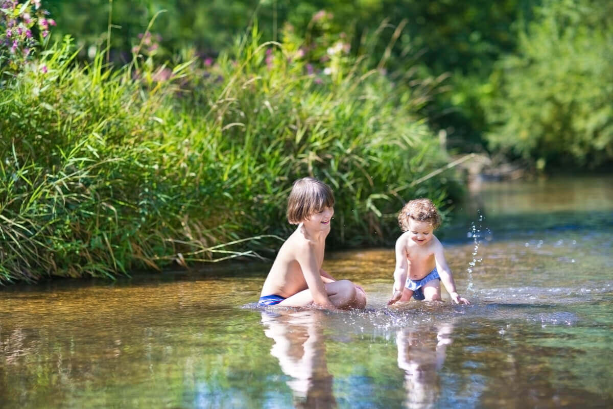 Børn leger i en sø med risiko for svømmerkløe