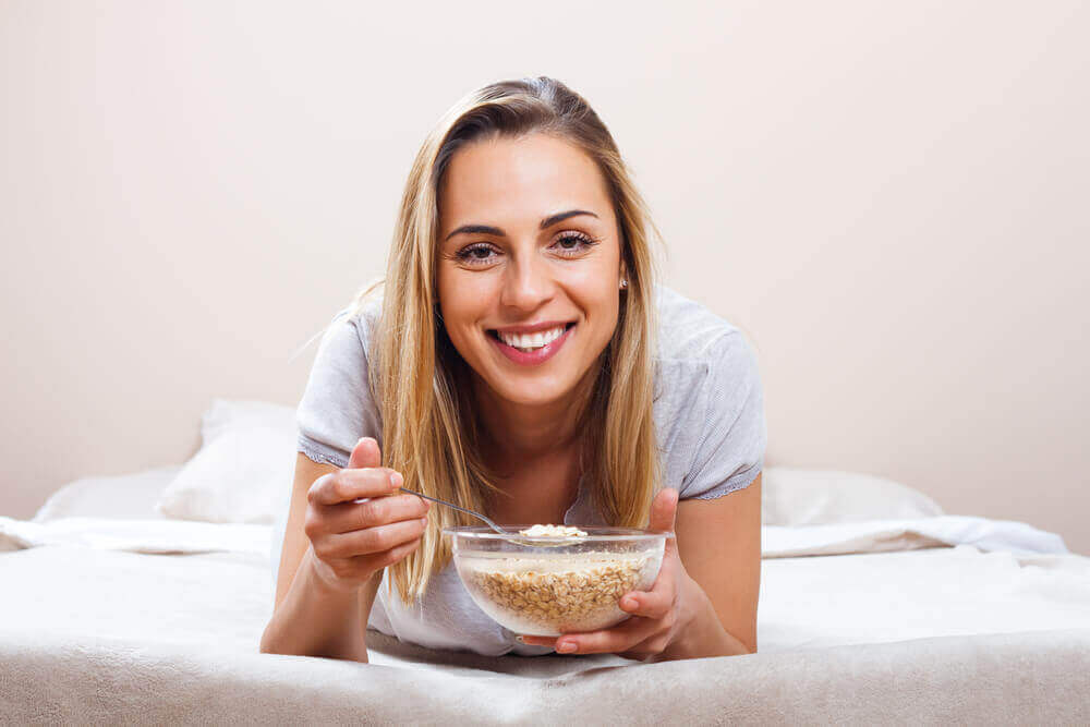 A woman eating a bowl of cereal.