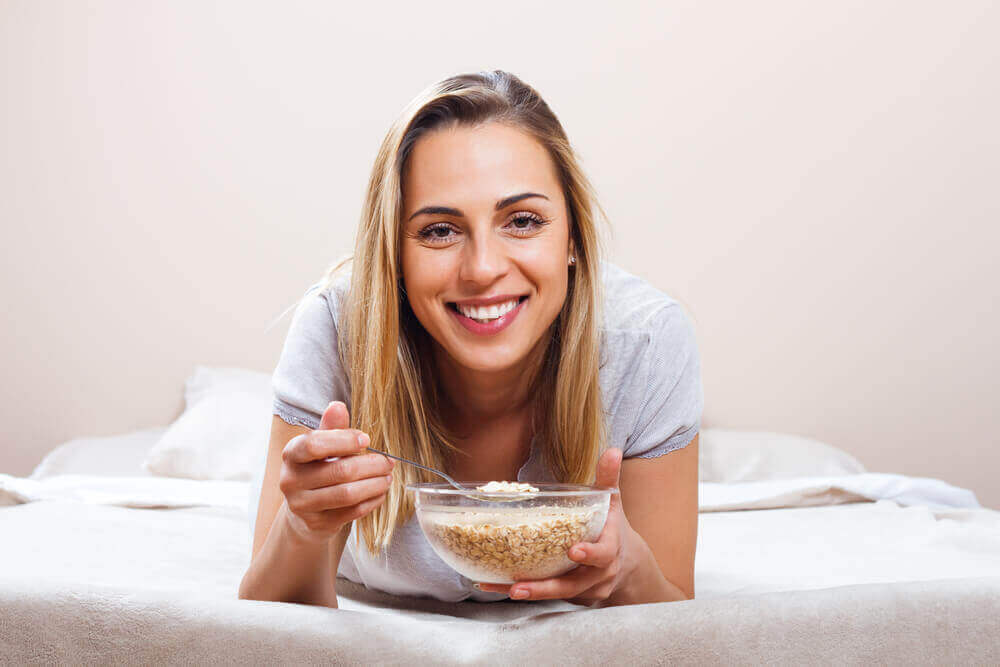 A woman eating a bowl of cereal.