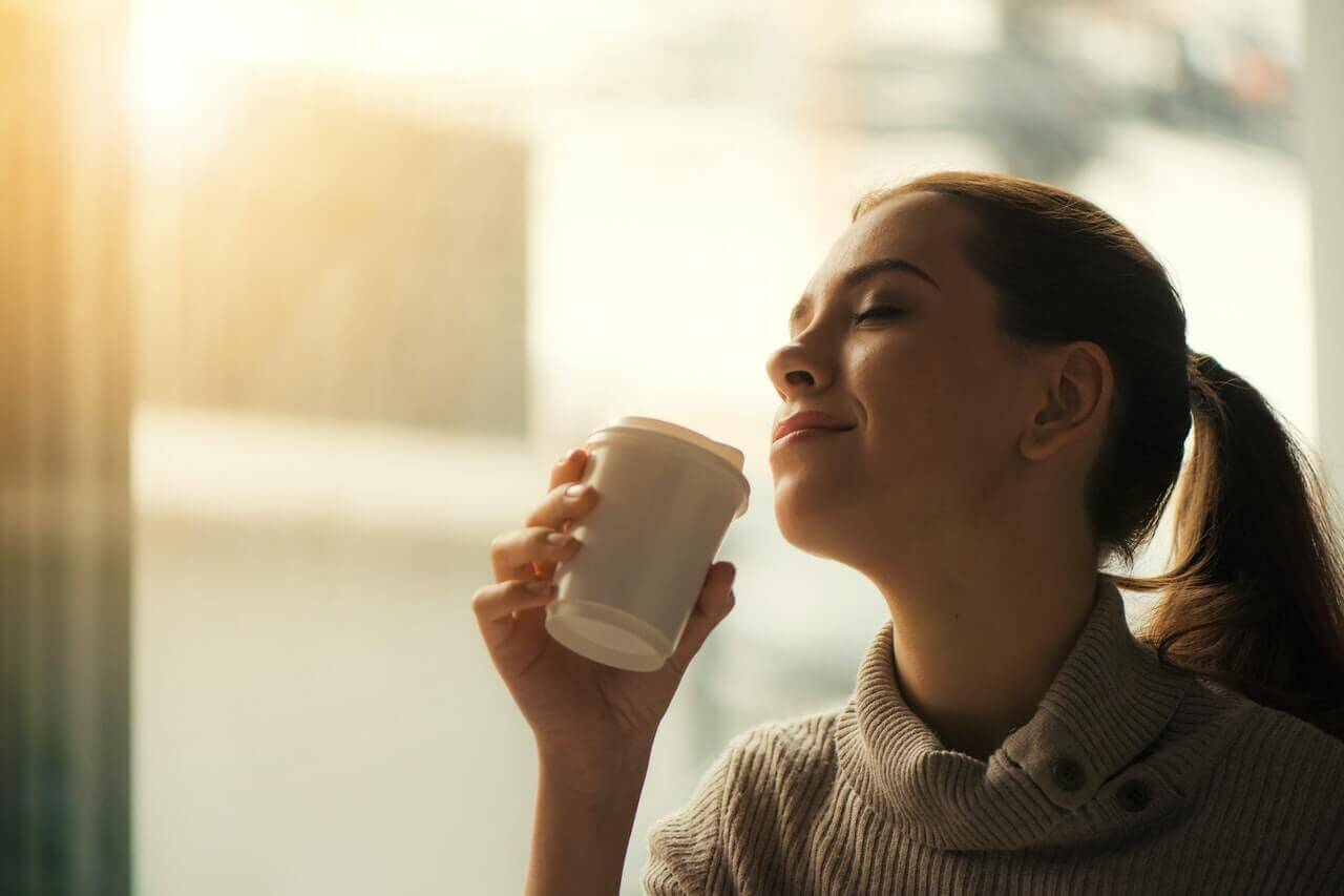 A woman sitting in a cafe drinking coffee.