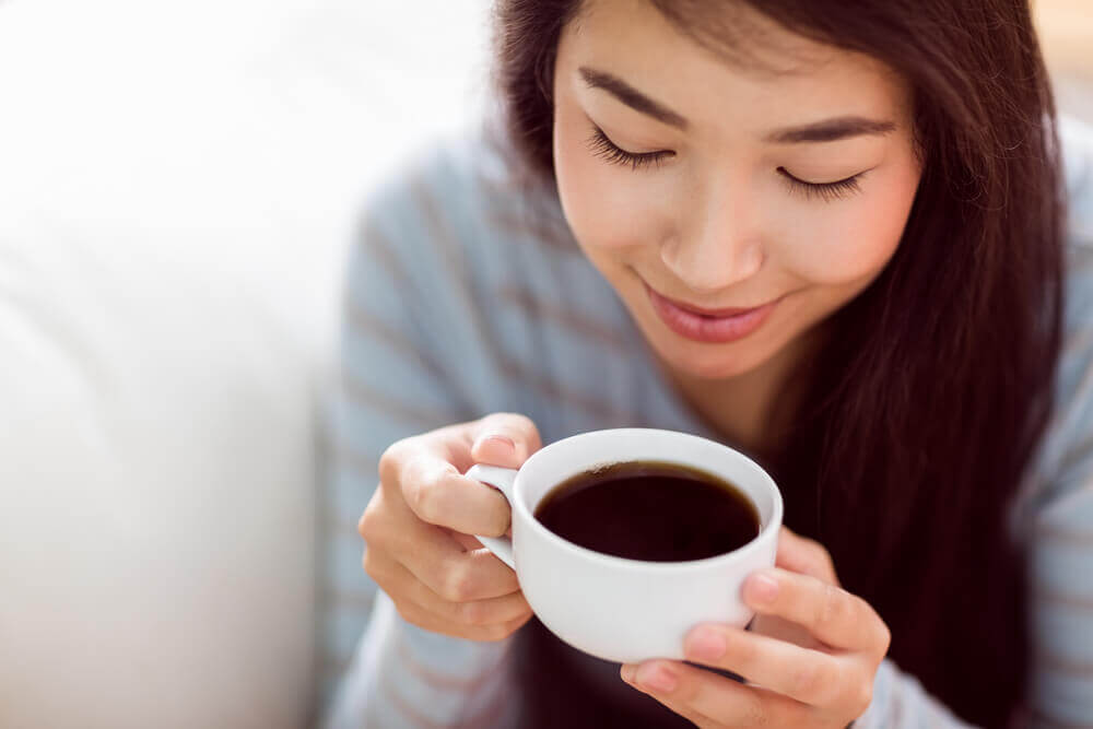 A woman drinking a cup of coffee.
