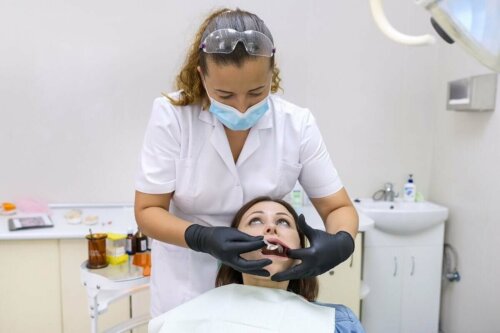 orthodontist taking a mould of a woman's teeth to fit braces