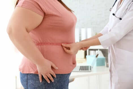 A doctor measuring a woman's waist.