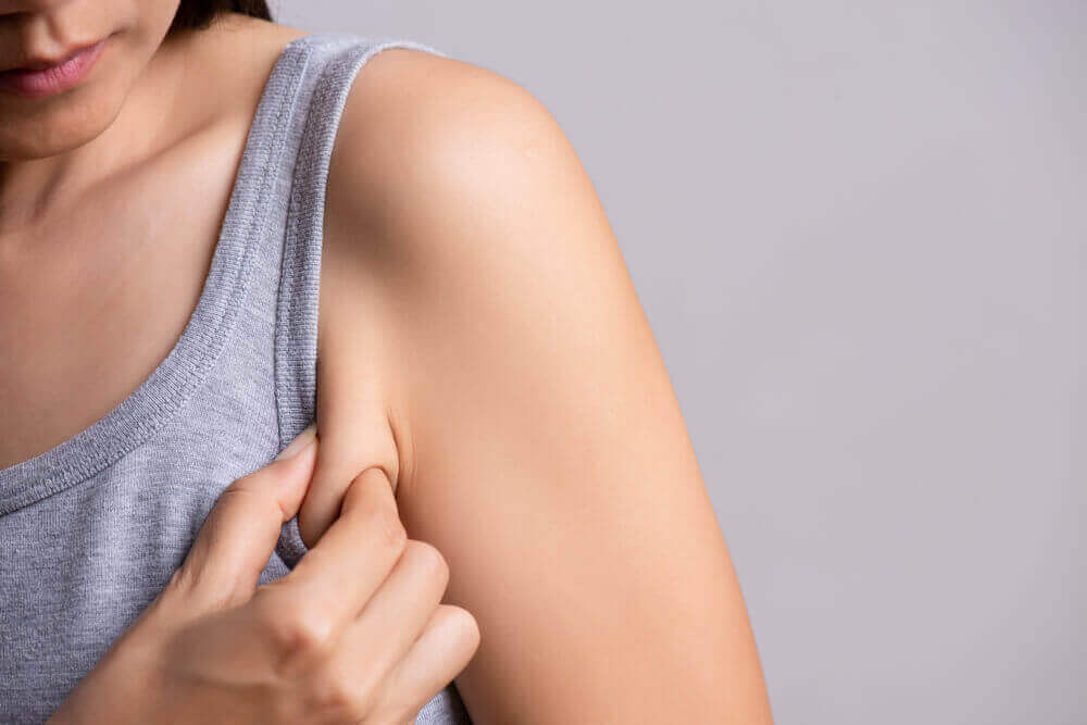 En kvinde holder i hud ved armen