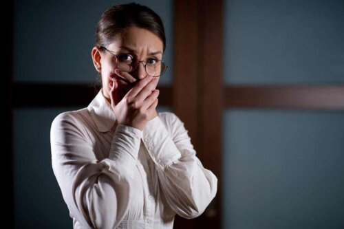 En kvinde, der oplever araknofobi, holder sig for munden