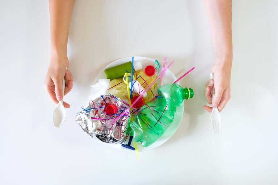 En person som gjør seg klar til å nyte en tallerken full av plastavfall.