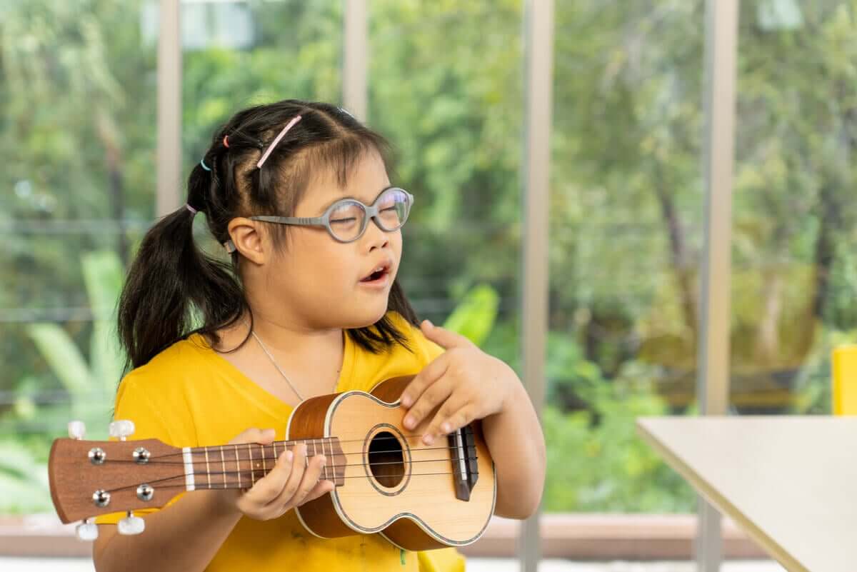 A child with Down syndrome playing the guitar.
