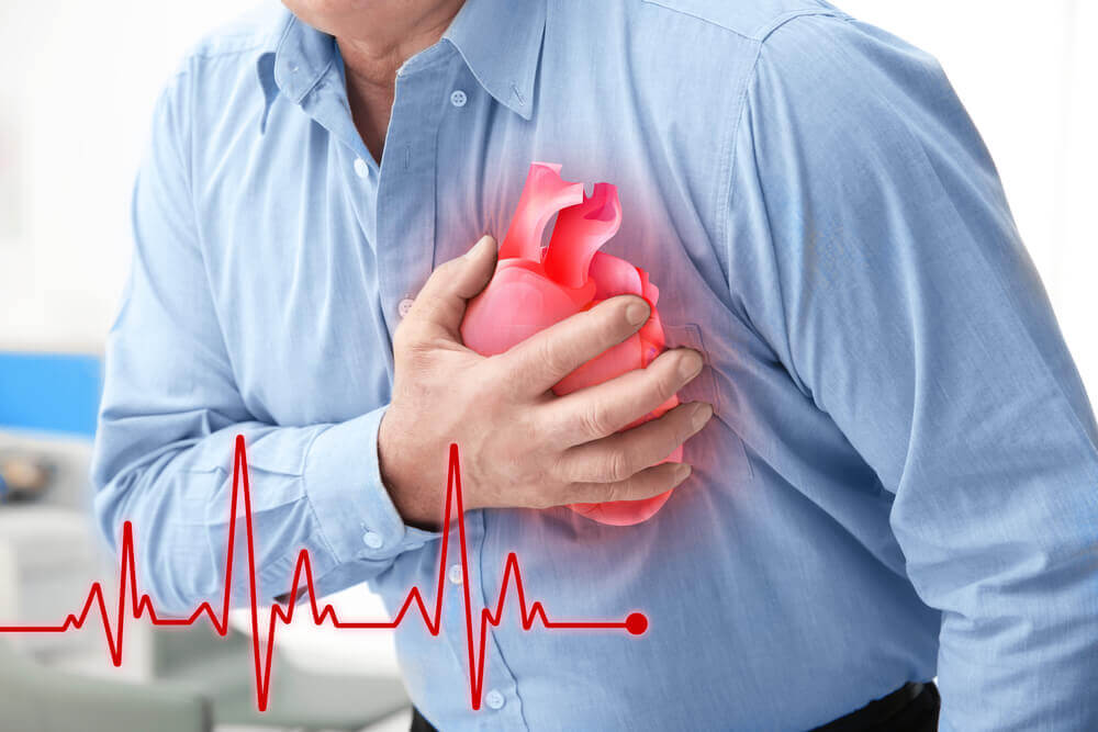A man suffering from a heart attack, clutching his chest.