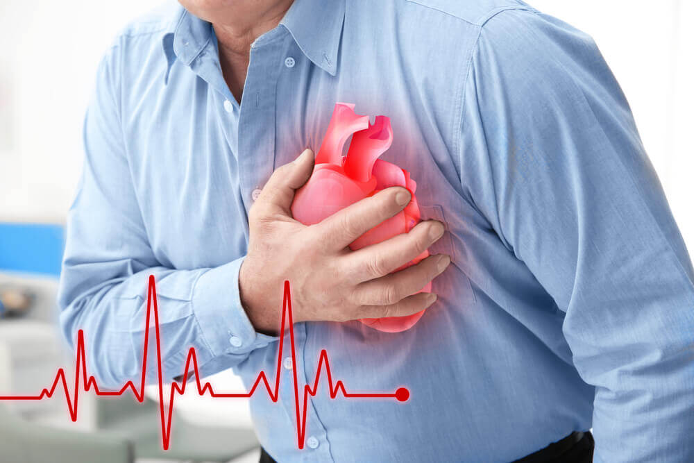 A man suffering from a heart attack, clutching his chest.