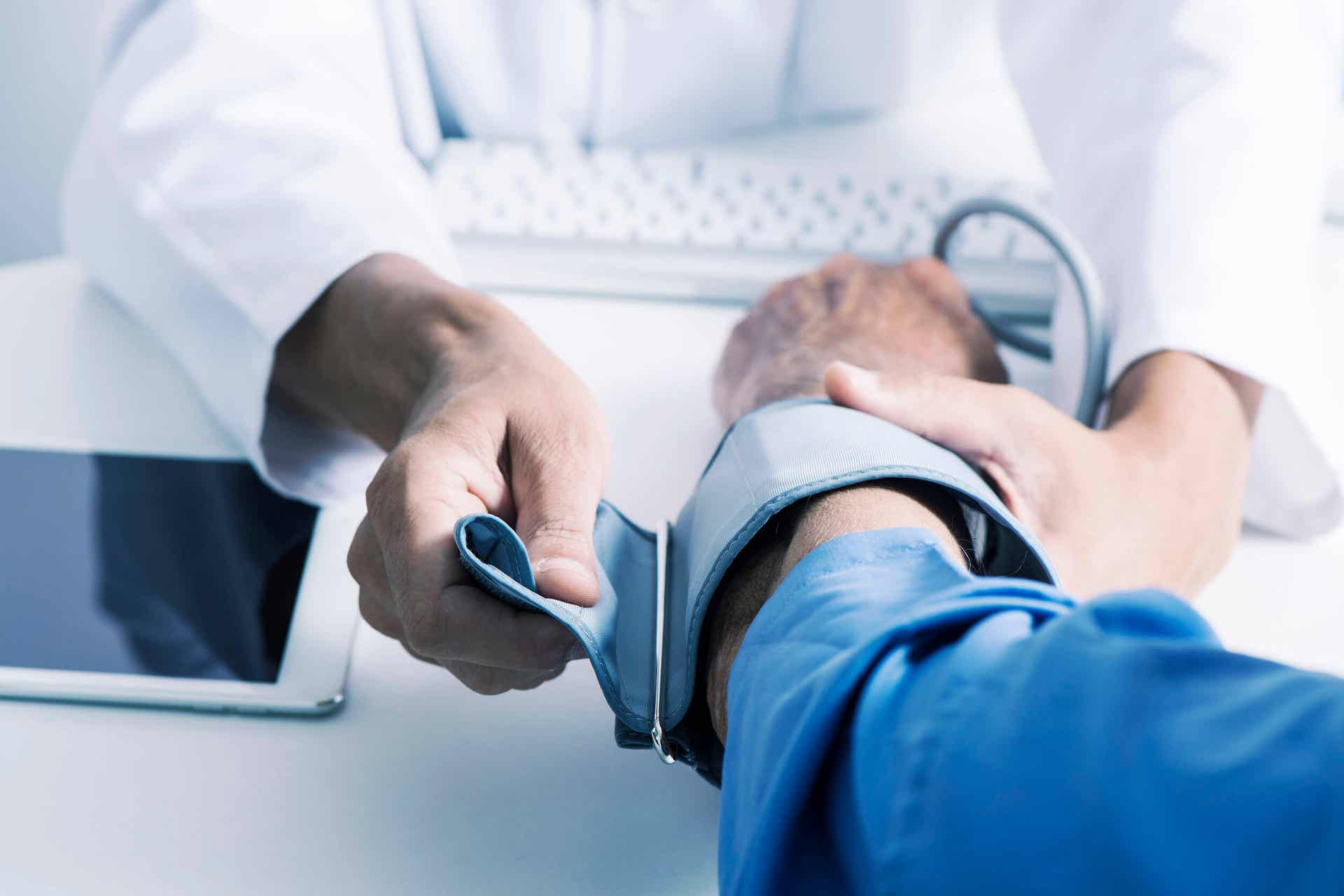 Læge tjekker patients blodtryk