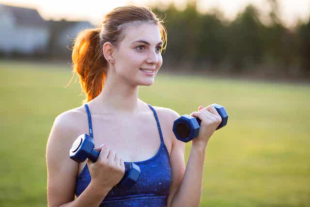 Eine Frau, die mit Gewichten trainiert.