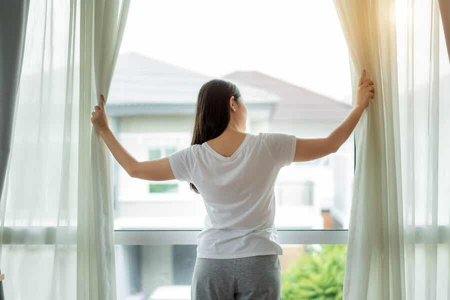 Schalldämpfer selbst bauen - so geht's - Eine Frau schaut aus ihrem Fenster
