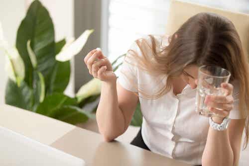 En kvinne som tar en dose av et antimigrainmedisin