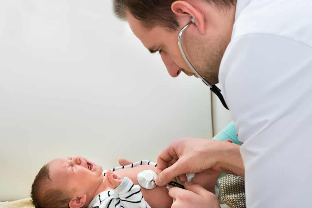 A pediatrician examining a newborn baby.