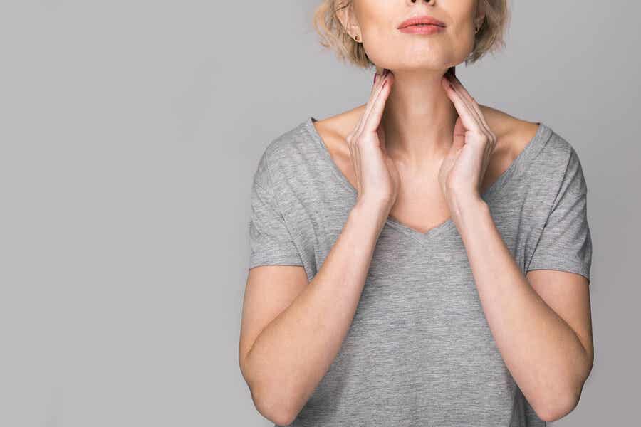 Non-Hodgkin-Lymphom (NHL): Frau tastet ihren Hals ab.