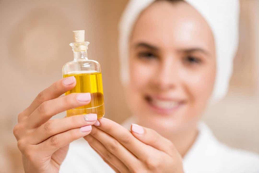A woman holding a bottle of Copaiba oil.