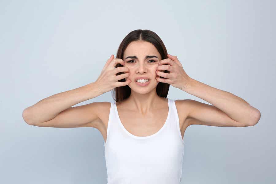 Kvinde, der kradser sit ansigt