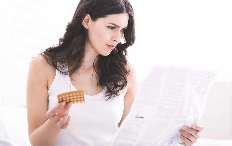 A woman reading information regarding her birth control pills.