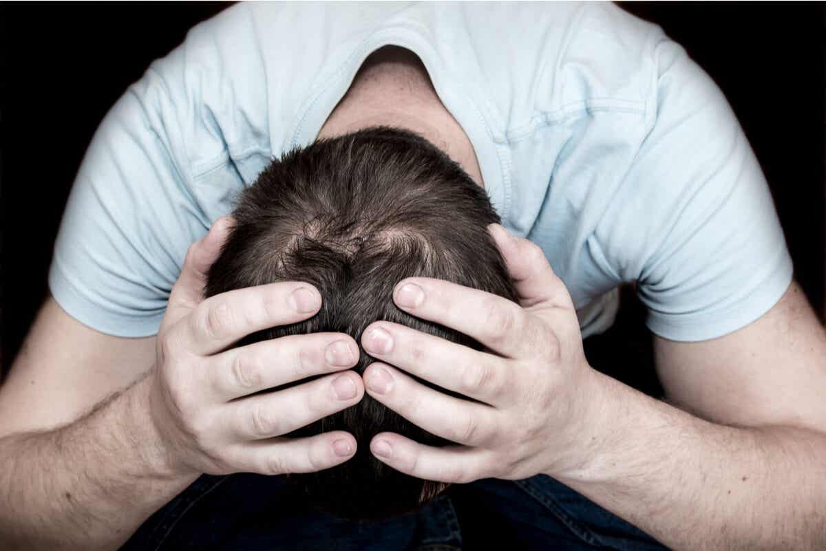 A man holds his head in his hands.