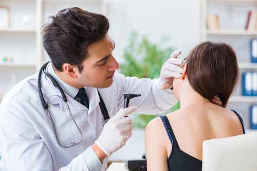 En læge, der undersøger en kvindes øre