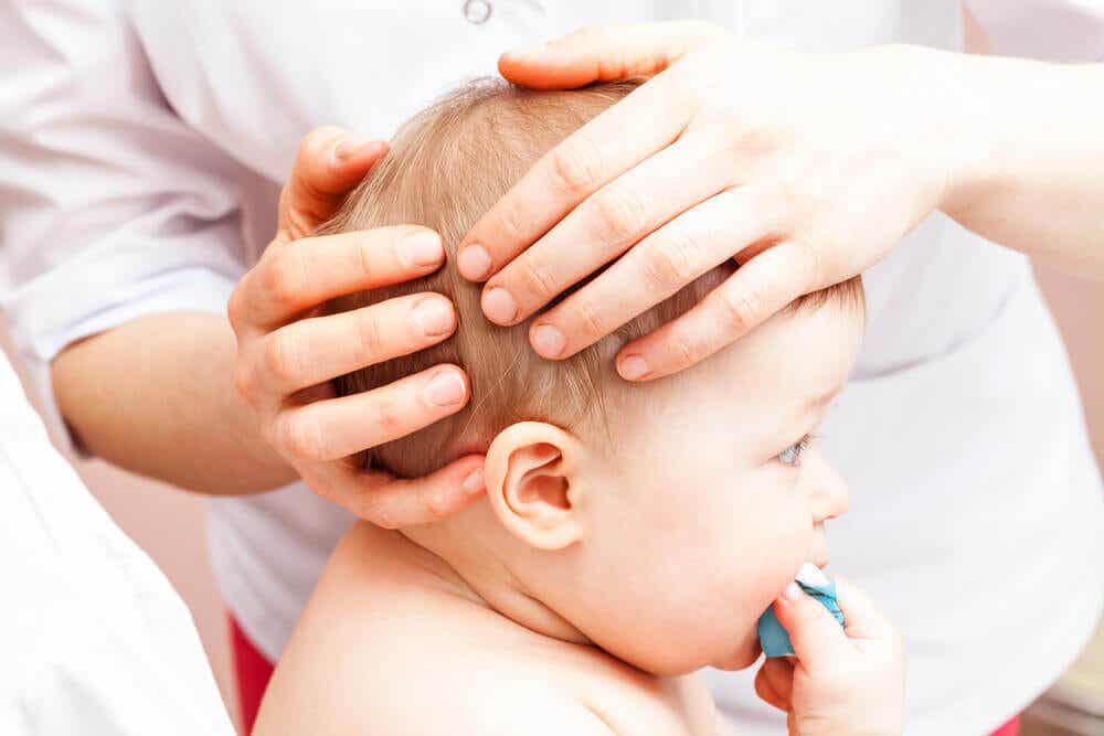 Pediatra badający główkę dziecka.