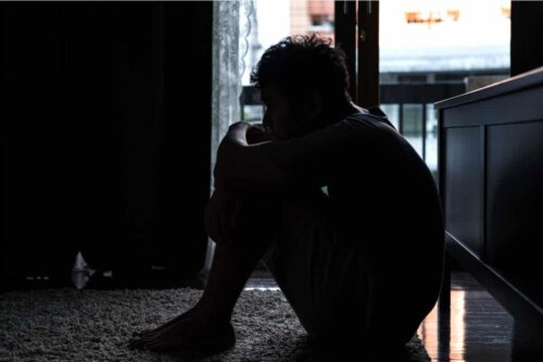 Person sad på gulvet i mørket trist og deprimeret