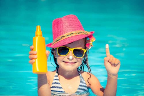 Sonnenschutz für Kinder - Mädchen mit Sonnenhut und Sonnencreme