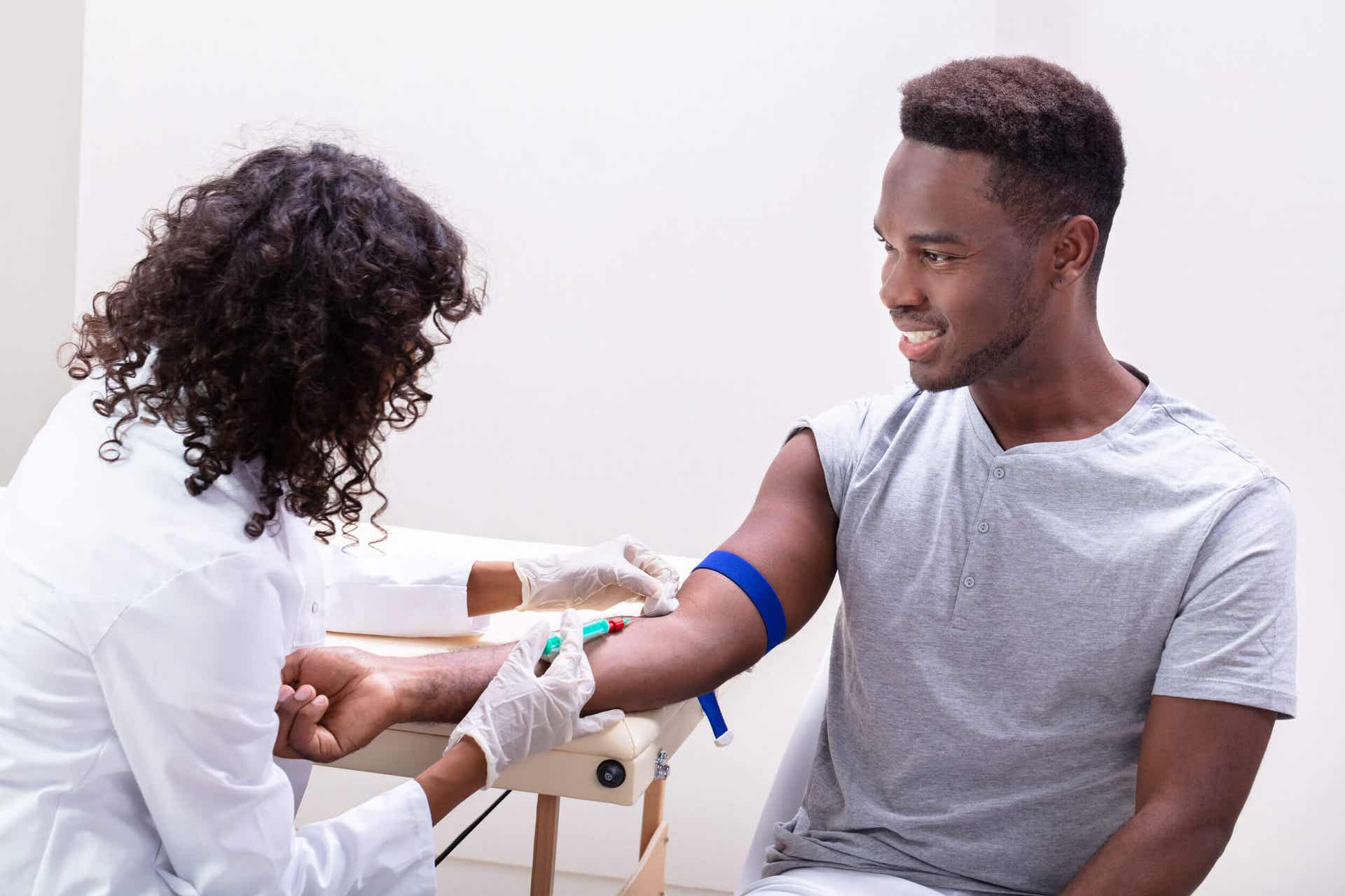 En kvinde, der tager blodprøve på ung mand