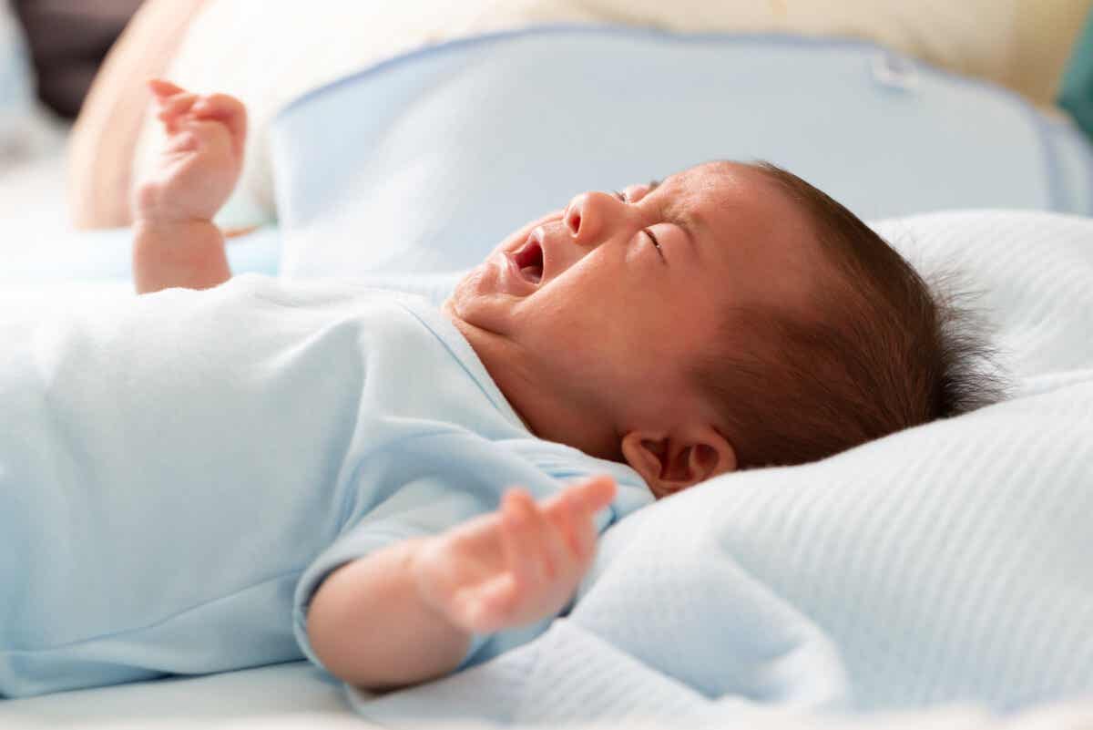 En baby som gråter på grunn av Sandifers syndrom
