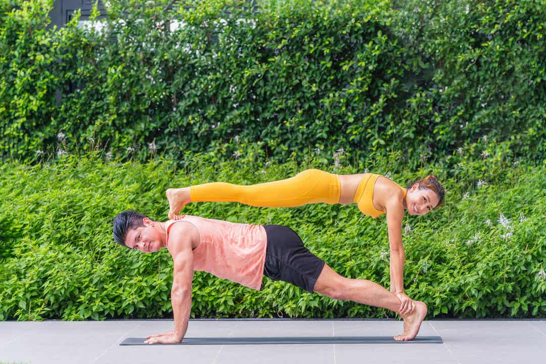 A man and woman holding an acrogym pose.