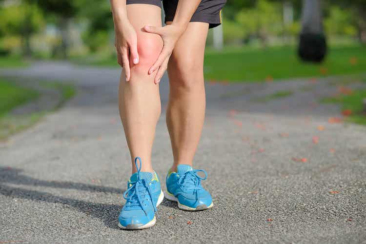 Eine Läuferin mit Schmerzen im Knie.