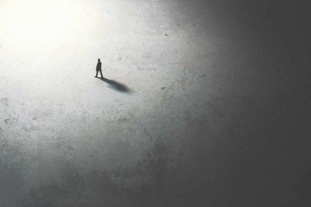 The silhouette of a person walking from darkness to light.