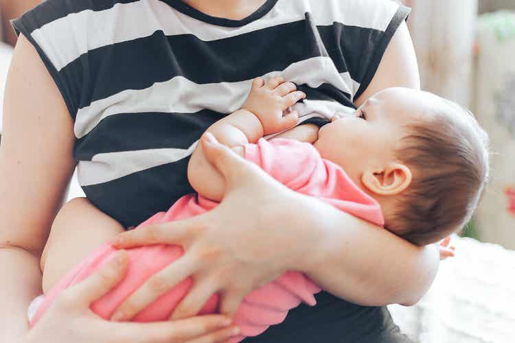 母乳育児中の母親の顔を見つめる赤ちゃん。