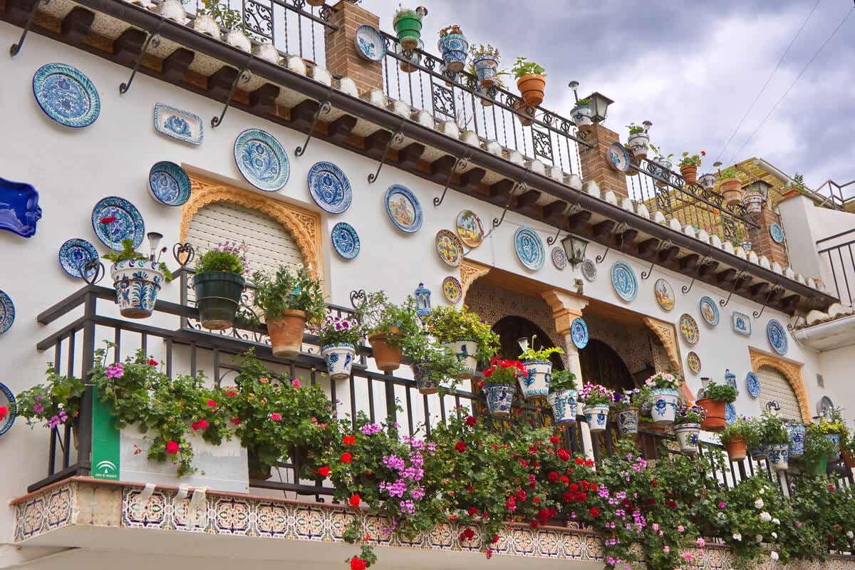 En balkon i andalusisk dækket med keramiske urtepotter og tallerkener