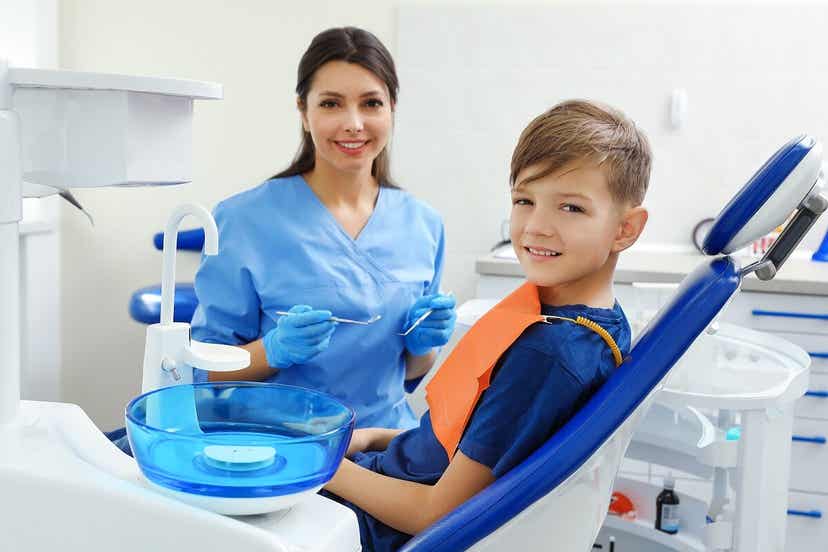 Et barn sitter i en tannlegestol.